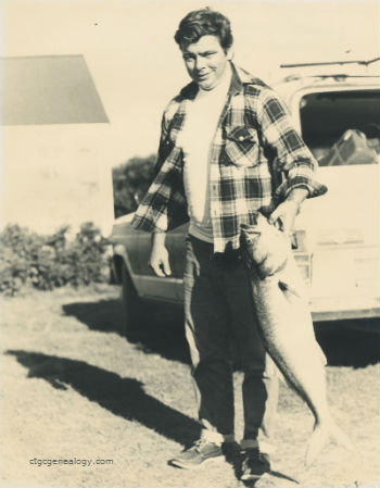 Charles E. Conrad holding his bluefish catch
